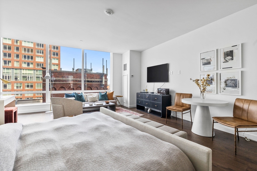 40 Trinity Place, Unit 1603 Boston, MA 02116 - Photo 2 of 11 a bedroom with furniture a large window and a flat screen tv