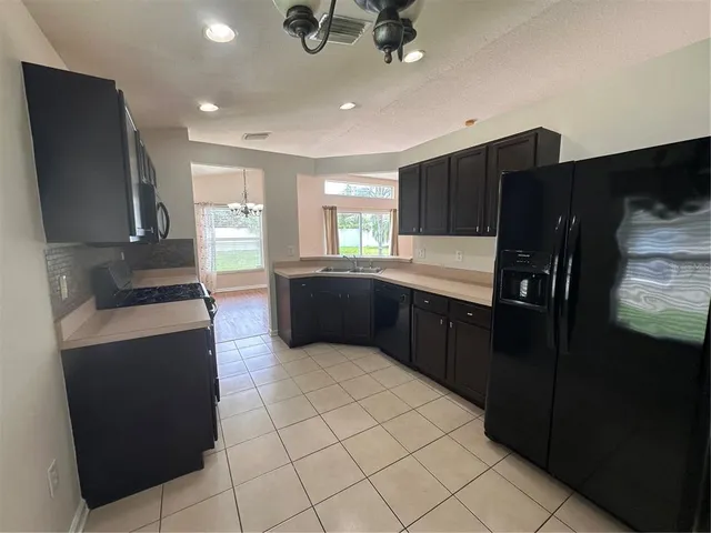 a large kitchen with a stove a refrigerator and a sink