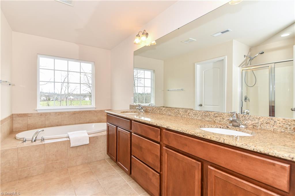 3137 Cranberry Ridge Drive High Point, NC 27265 - Photo 12 of 25 This "spa-like" master bathroom has a granite countertop double vanity, tile flooring, and soaking tub.