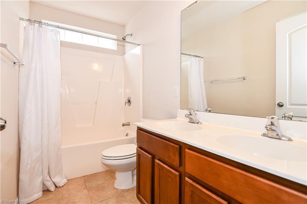 3137 Cranberry Ridge Drive High Point, NC 27265 - Photo 17 of 25 The second level full bathroom has tile flooring, a shower/tub combination with transom window and a double sink vanity.