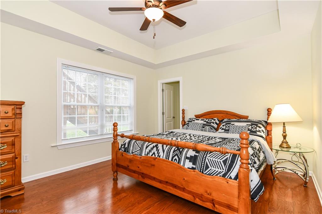 3137 Cranberry Ridge Drive High Point, NC 27265 - Photo 21 of 25 The fifth bedroom has a tray ceiling, fan/light combination, double window, laminate wood flooring, and a walk-in closet.