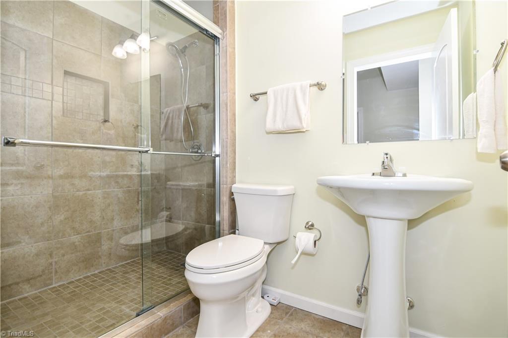 3137 Cranberry Ridge Drive High Point, NC 27265 - Photo 22 of 25 The basement full bathroom has single vessel sink, tile flooring, and a large tile shower with custom niche.