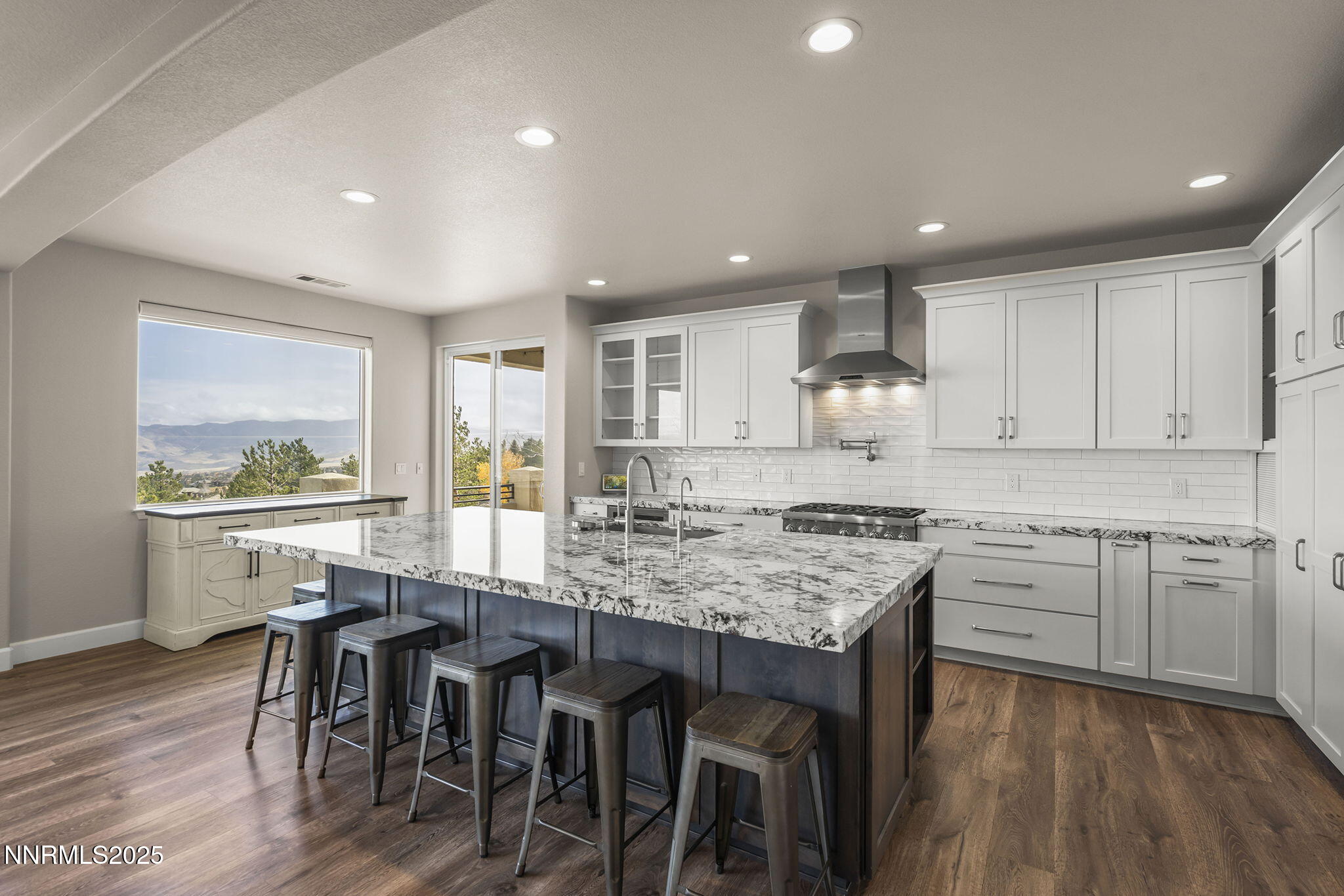 5640 Rue St Tropez Reno, NV 89511 - Photo 11 of 55 a kitchen with a dining table chairs cabinets wooden floor and appliances