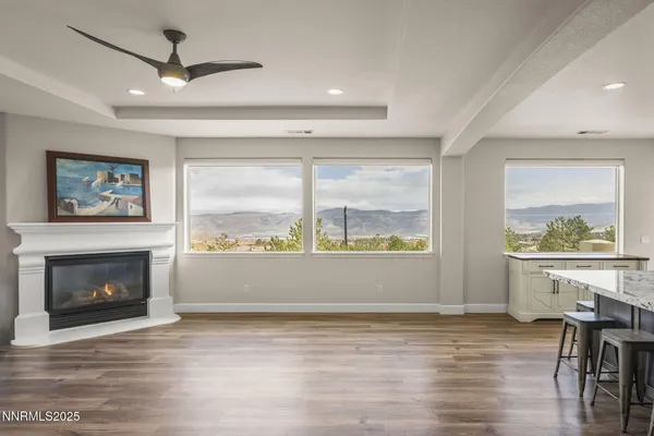a dining hall with stainless steel appliances granite countertop a stove oven a refrigerator a dining table and chairs with wooden floor