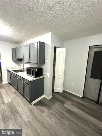 a kitchen with granite countertop a refrigerator and a sink