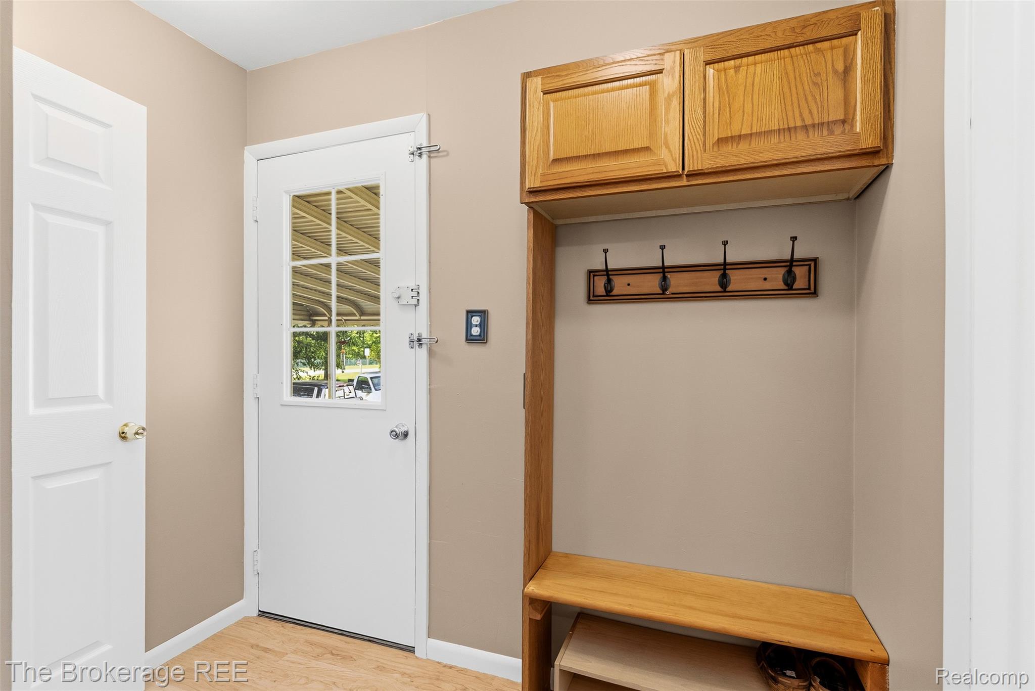 6509 Silver Lake Road Linden, MI 48451 - Photo 22 of 43 Entryway featuring a built-in wooden hall tree with upper cabinetry, a storage bench, and a wall-mounted coat rack