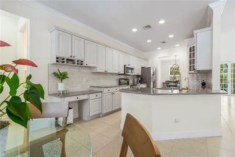 a kitchen with stainless steel appliances granite countertop sink a refrigerator and white cabinets