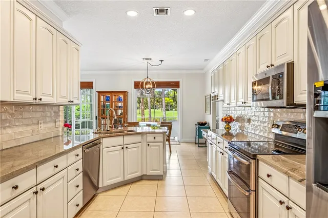a kitchen with stainless steel appliances a sink window and cabinets