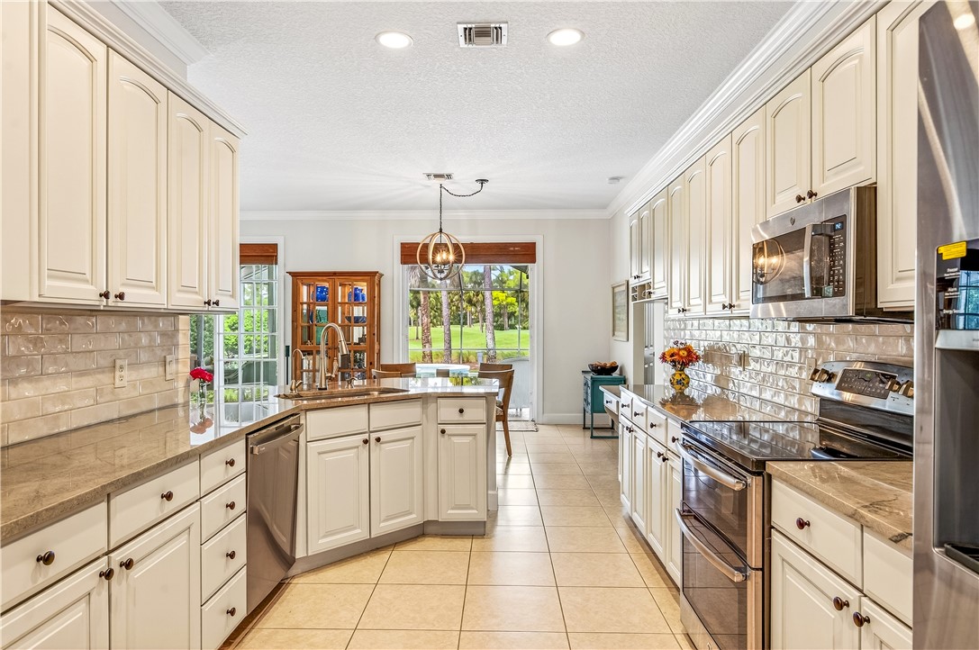 886 Carolina Circle Southwest Vero Beach, FL 32962 - Photo 12 of 36 a kitchen with stainless steel appliances a sink window and cabinets
