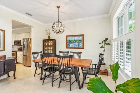 a view of a dining room and livingroom with furniture wooden floor a chandelier