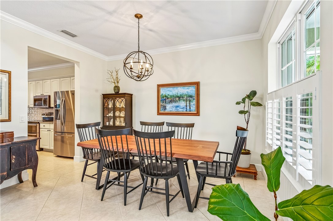 886 Carolina Circle Southwest Vero Beach, FL 32962 - Photo 18 of 36 a view of a dining room and livingroom with furniture wooden floor a chandelier