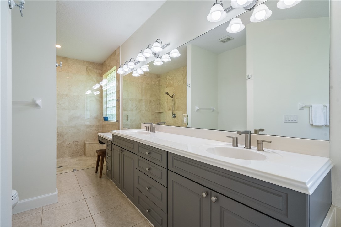886 Carolina Circle Southwest Vero Beach, FL 32962 - Photo 22 of 36 a bathroom with a sink double vanity and a mirror