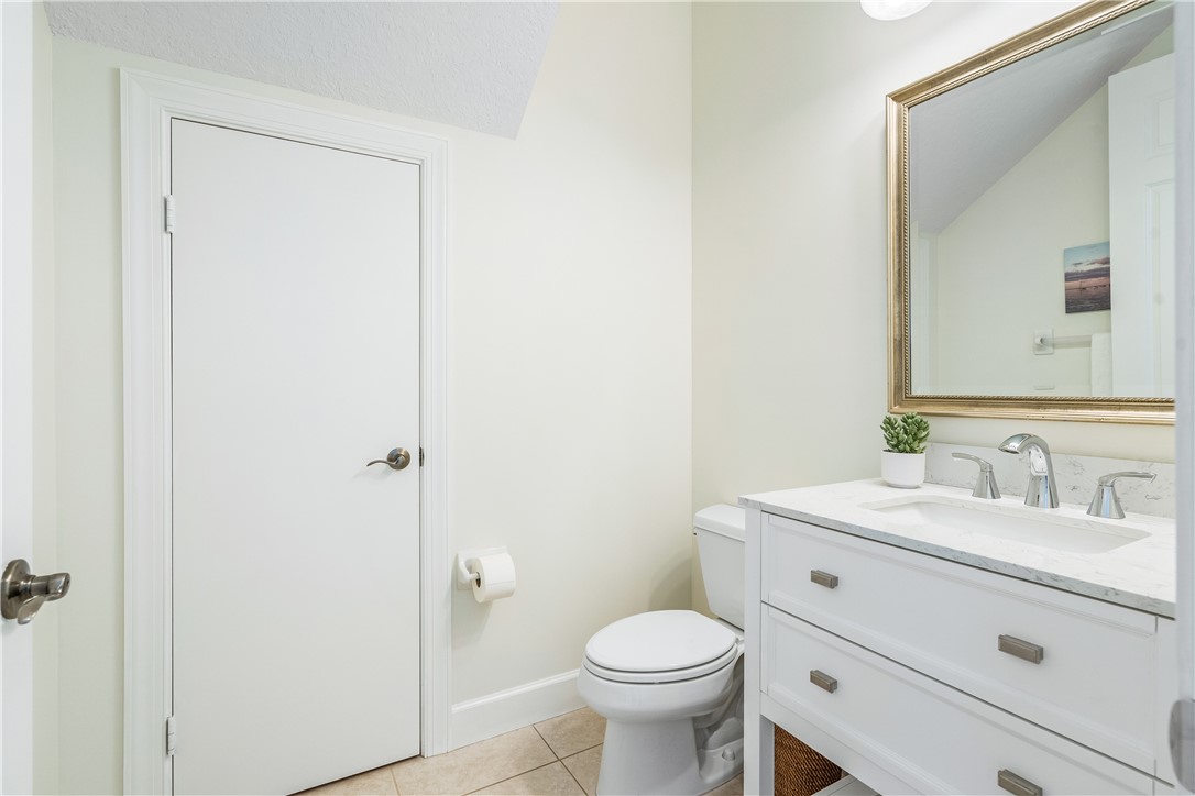886 Carolina Circle Southwest Vero Beach, FL 32962 - Photo 26 of 36 a bathroom with a sink a toilet a mirror and vanity