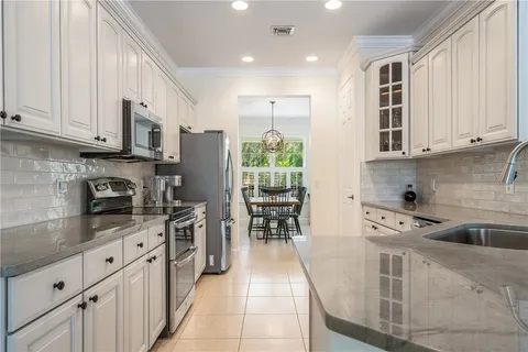 a kitchen with stainless steel appliances granite countertop a stove a sink and white cabinets