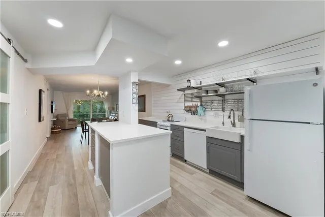 a kitchen with a sink a refrigerator and chairs
