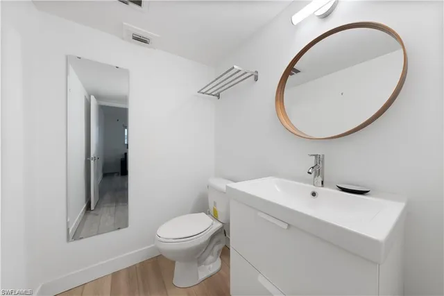 a bathroom with a sink a toilet and a mirror