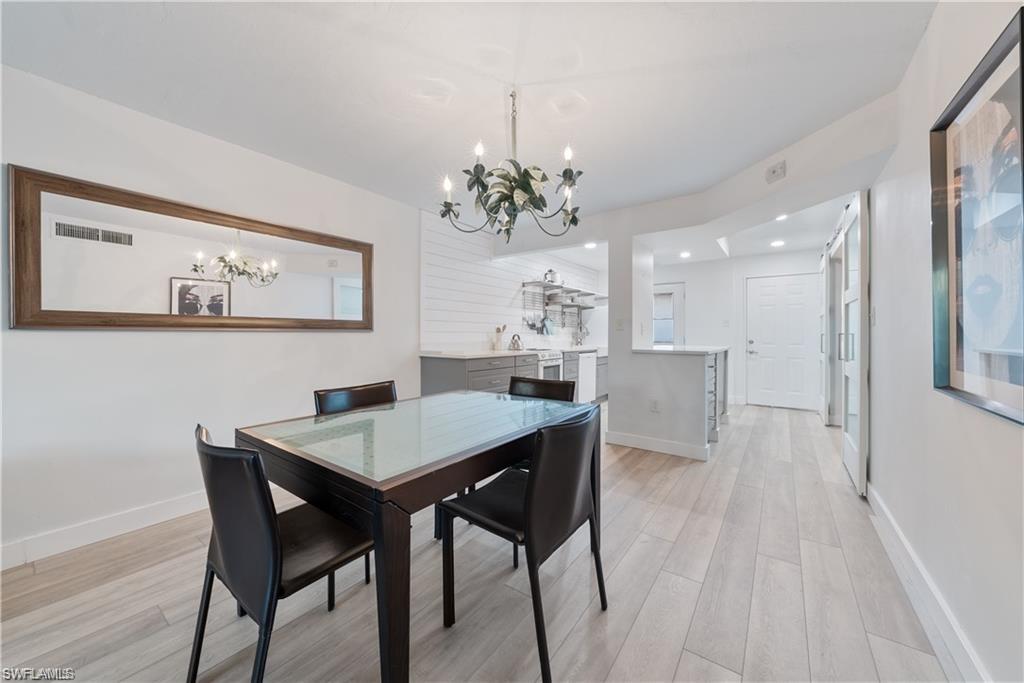 72 7th Street South, Unit 310 Naples, FL 34102 - Photo 9 of 24 a view of a dining room with furniture and wooden floor