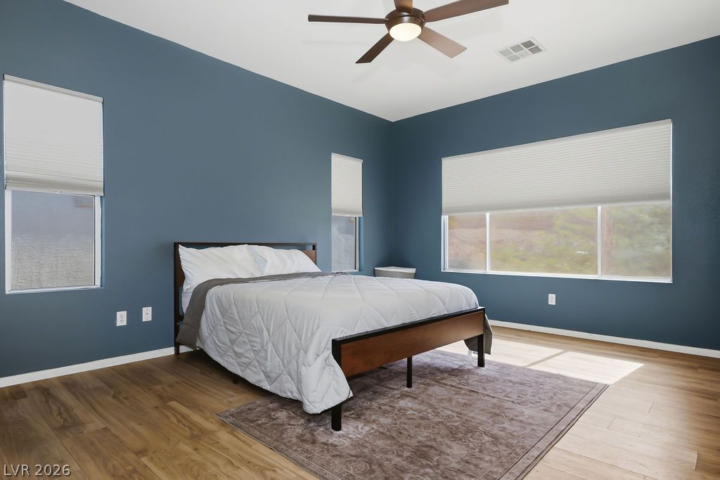 754 Solitude Point Avenue Henderson, NV 89012 - Photo 28 of 38 Hardwood floors and generous windows create a light and open atmosphere in this spacious sleeping quarter.