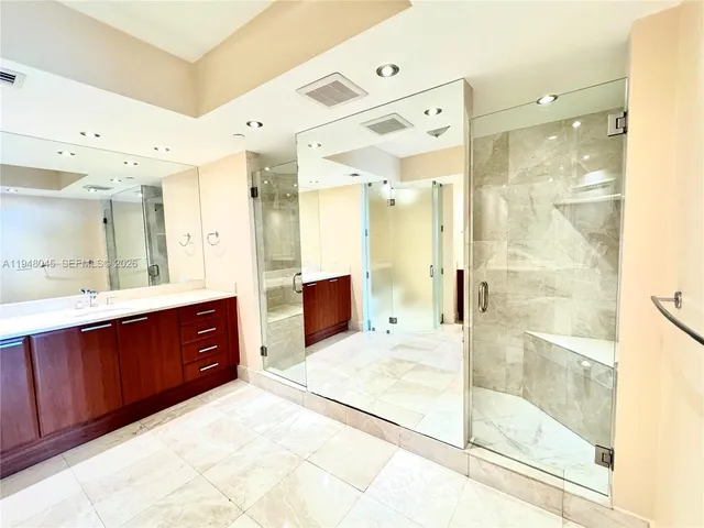 a spacious bathroom with a granite countertop sink mirror and shower