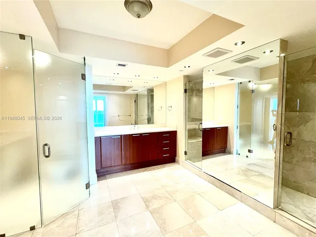 a bathroom with a mirror sink and glass door shower