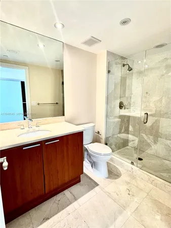 a bathroom with a sink toilet double vanity and shower