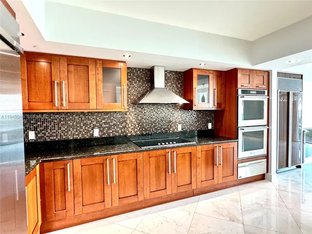 a kitchen with stainless steel appliances granite countertop a refrigerator and cabinets