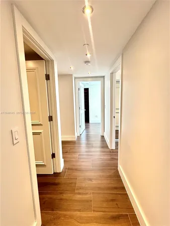 a view of a hallway with wooden floor