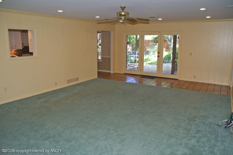 6910 Calumet Road Amarillo, TX 79106 - Photo 12 of 26 an empty room with wooden floor and windows