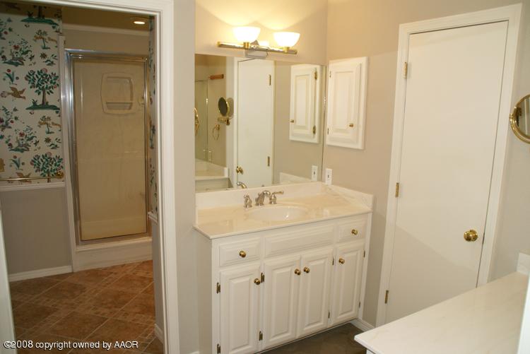 6910 Calumet Road Amarillo, TX 79106 - Photo 18 of 26 a bathroom with a sink a mirror and a shower