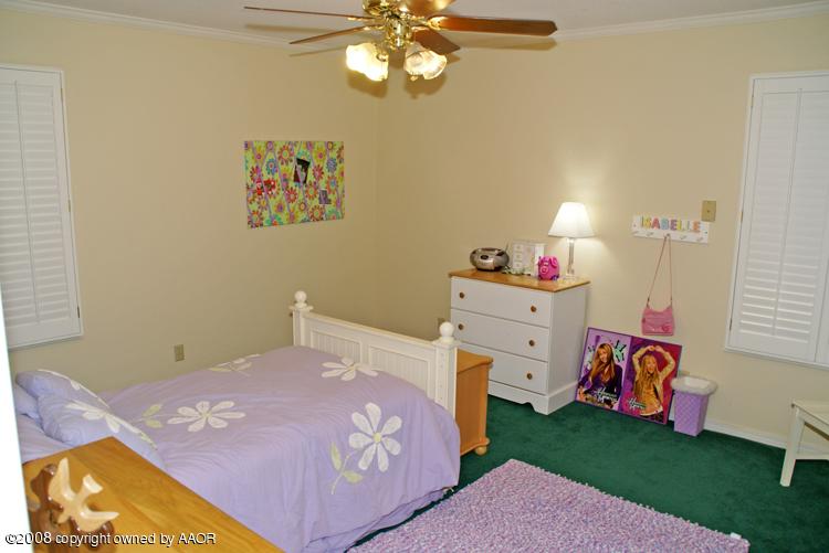 6910 Calumet Road Amarillo, TX 79106 - Photo 24 of 26 a bedroom with a bed and a chandelier