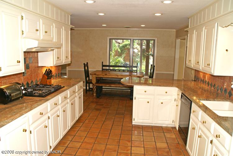6910 Calumet Road Amarillo, TX 79106 - Photo 6 of 26 a kitchen with stainless steel appliances a stove a sink and a refrigerator