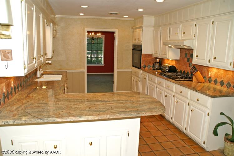 6910 Calumet Road Amarillo, TX 79106 - Photo 7 of 26 a kitchen with stainless steel appliances granite countertop a stove a sink and a refrigerator