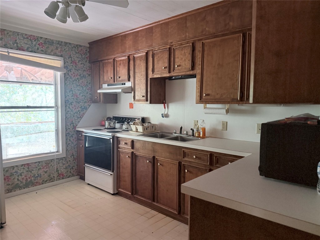 526 Mt Pisgah Road Woodville, TX 75979 - Photo 22 of 23 a kitchen with stainless steel appliances a sink a stove a microwave a refrigerator and cabinets