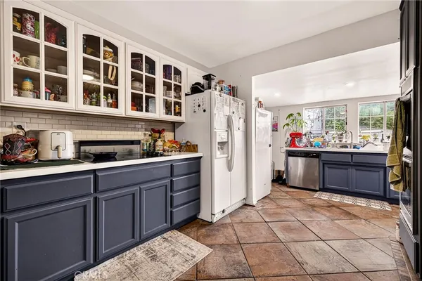 a kitchen with stainless steel appliances granite countertop a refrigerator and wooden cabinets