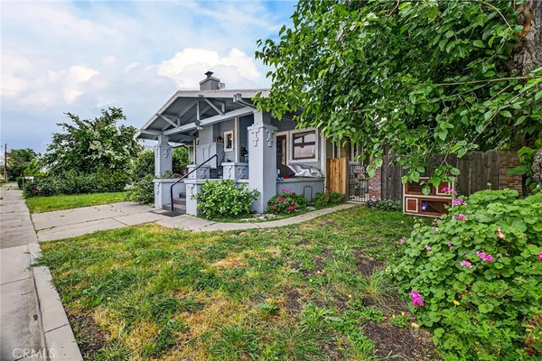 a view of a patio with table and chairs potted plants with floor to ceiling window and potted plants