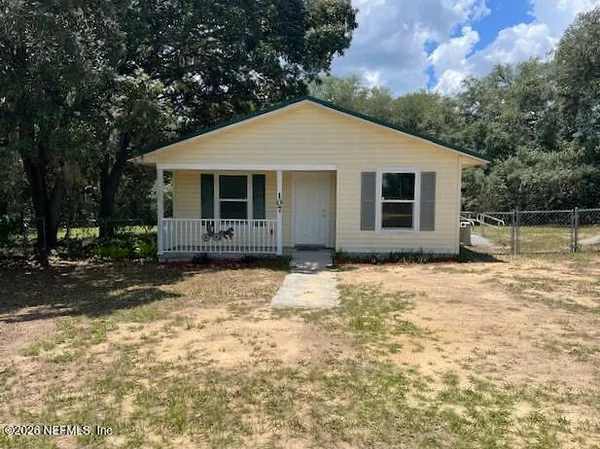 a front view of house with yard and trees around