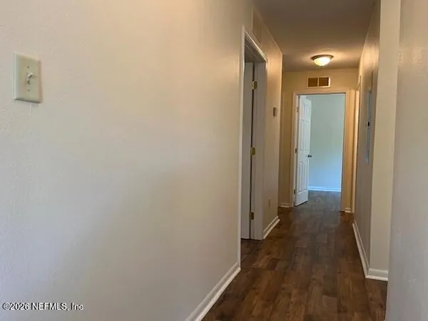 a view of a hallway with wooden floor