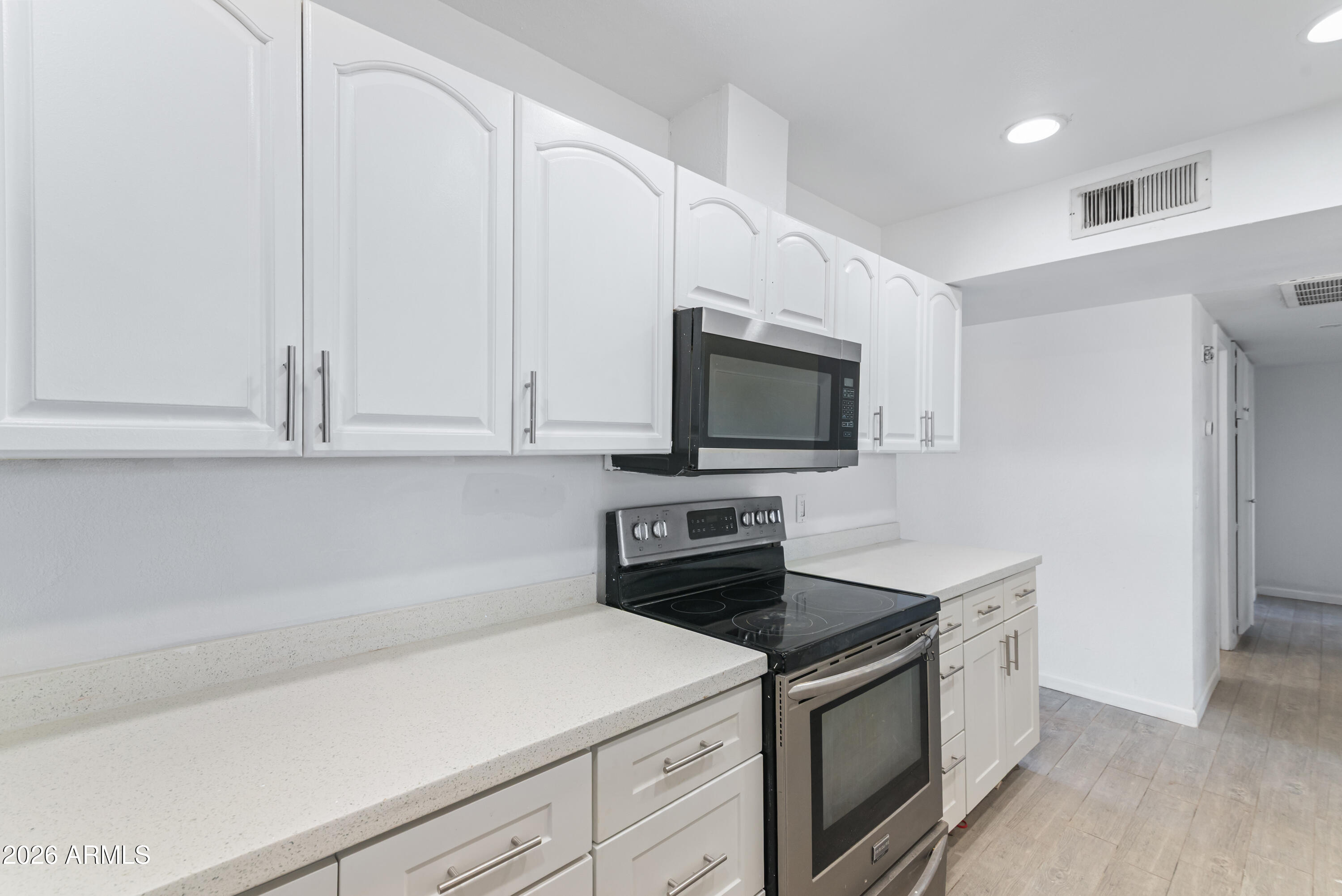 860 West McLellan Road Mesa, AZ 85201 - Photo 4 of 26 a kitchen with white cabinets and stainless steel appliances