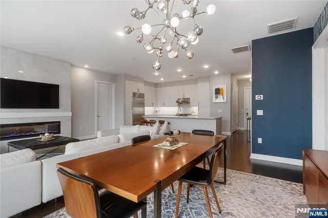 a room with stainless steel appliances kitchen island granite countertop a dining table and chairs