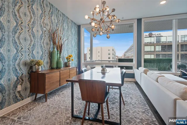 a view of a dining room with furniture a chandelier and wooden floor
