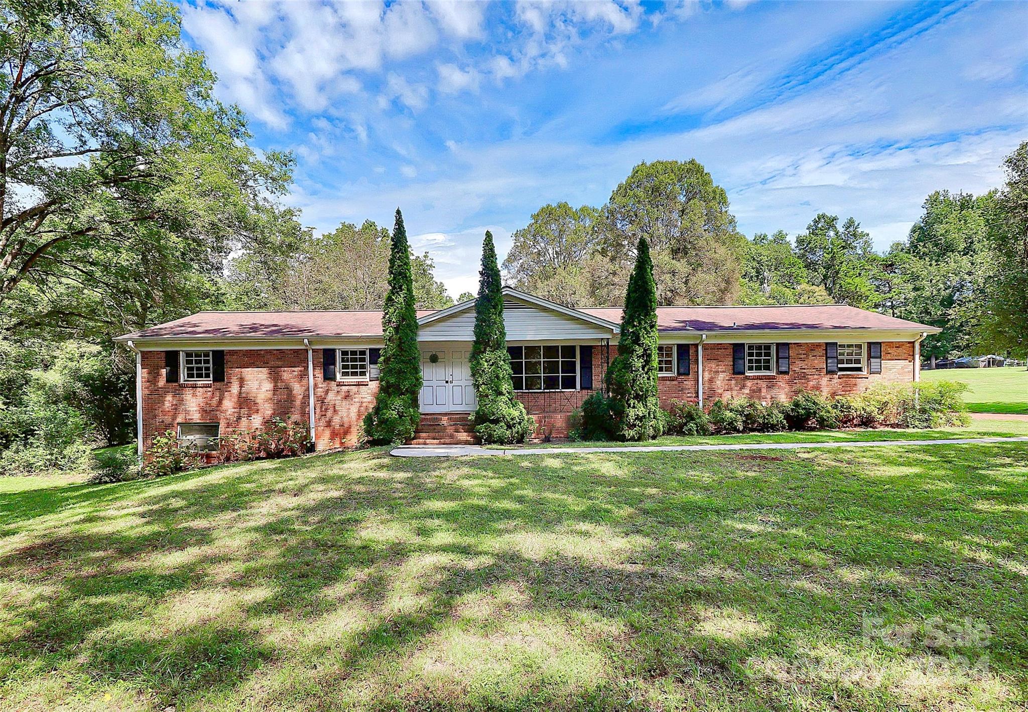 9811 Hannon Road Mint Hill, NC 28227 - Photo 1 of 27 a view of a big house with a big yard and large trees