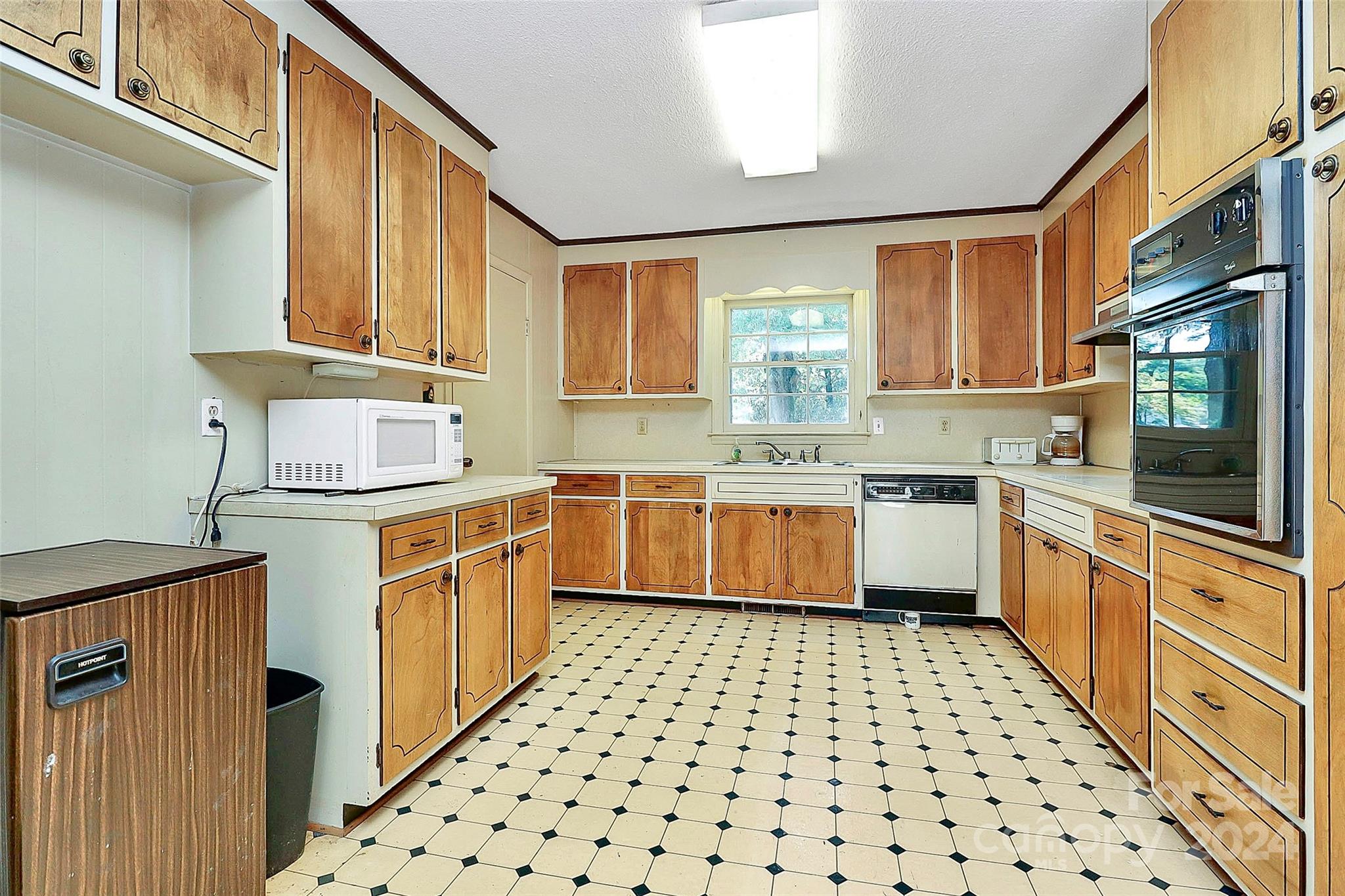 9811 Hannon Road Mint Hill, NC 28227 - Photo 8 of 27 a kitchen with a sink a stove top oven cabinets and a window