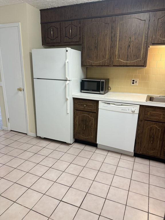 310 Codman Hill Road, Unit 34D Boxborough, MA 01719 - Photo 16 of 17 a kitchen with a refrigerator sink stove and cabinets