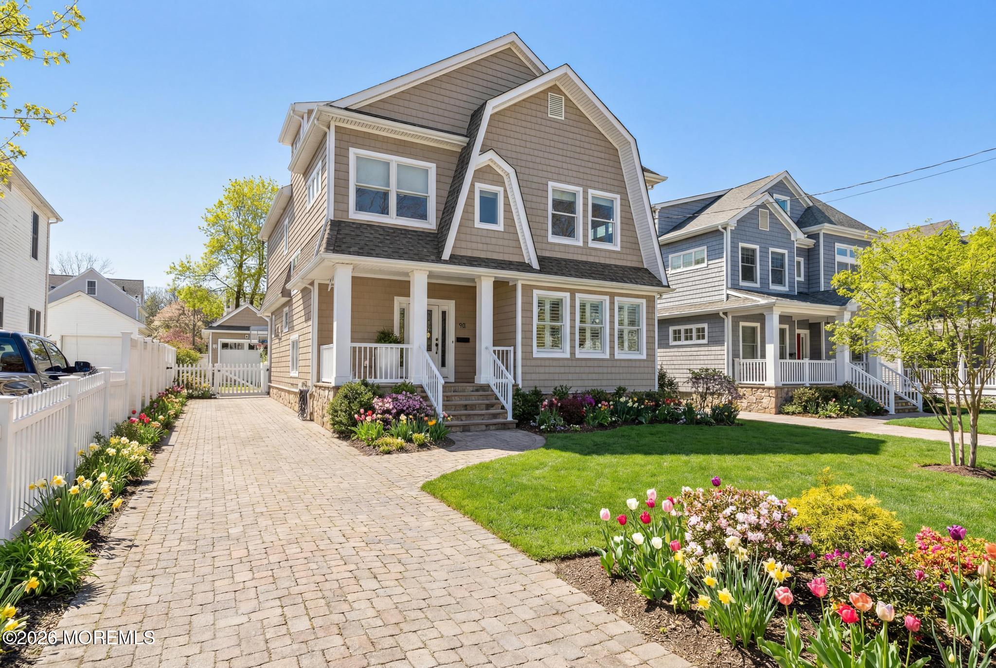 90 Washington Street Rumson, NJ 07760 - Photo 23 of 31 a front view of a house with a garden and trees