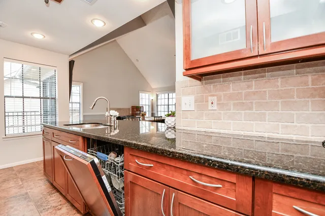 a kitchen with stainless steel appliances granite countertop a sink a stove and a refrigerator