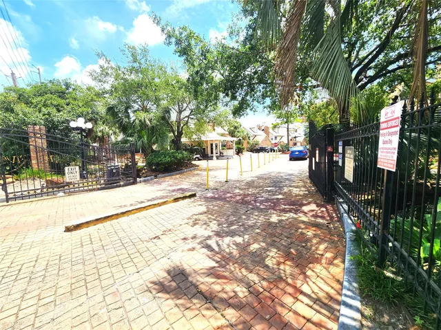 a view of a park with potted plants and large trees