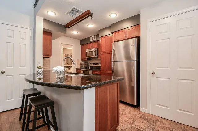 a kitchen with kitchen island a sink appliances and cabinets