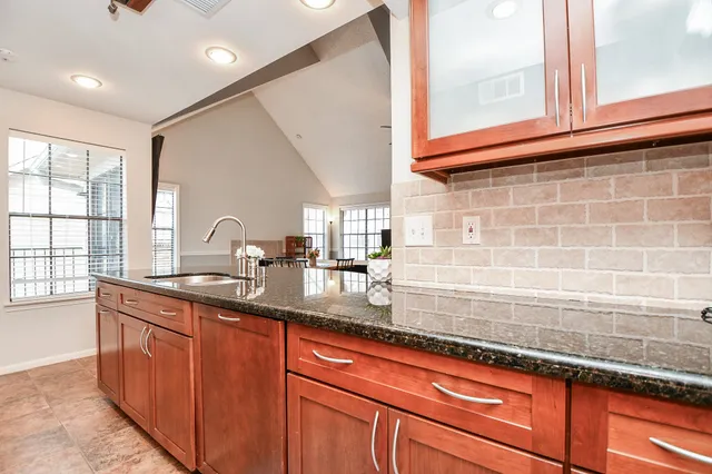 a kitchen with stainless steel appliances granite countertop a sink and a window