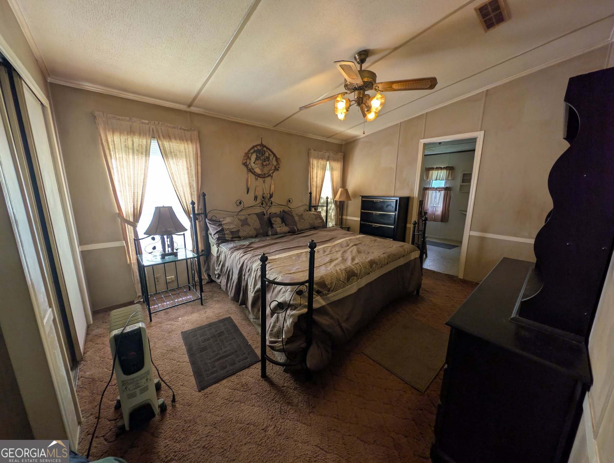 460 Etheridge Mill Road Milner, GA 30257 - Photo 18 of 27 a bedroom with a bed and a chandelier