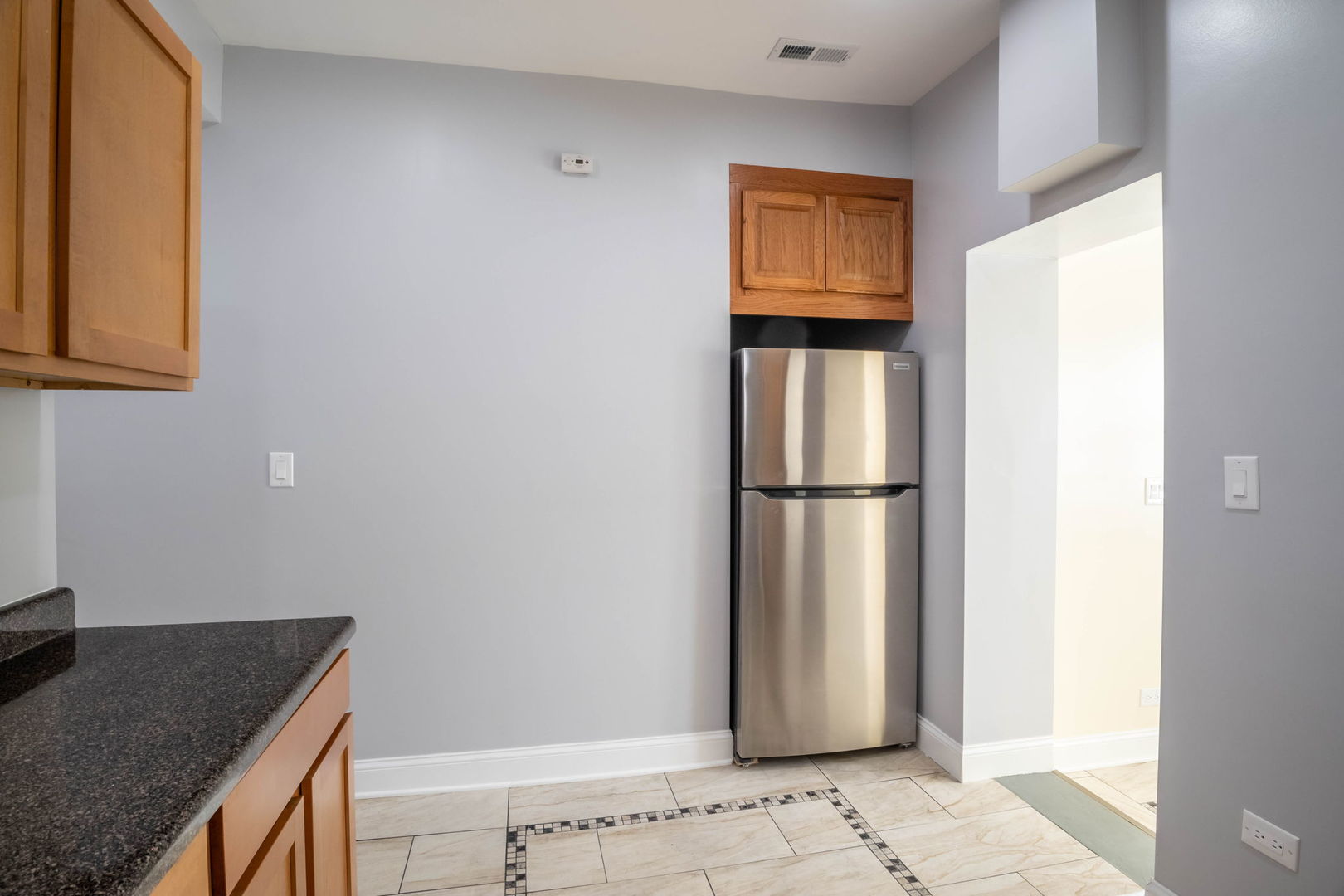 4837 West Monroe Street, Unit 1 Chicago, IL 60644 - Photo 17 of 21 a kitchen with a refrigerator and cabinets